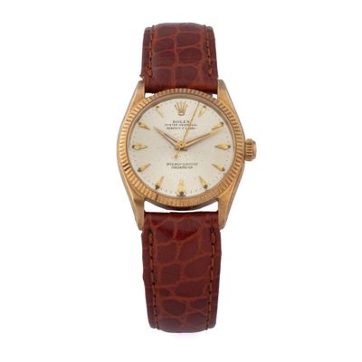 gros plan d'une montre sur fond blanc avec un bracelet marron