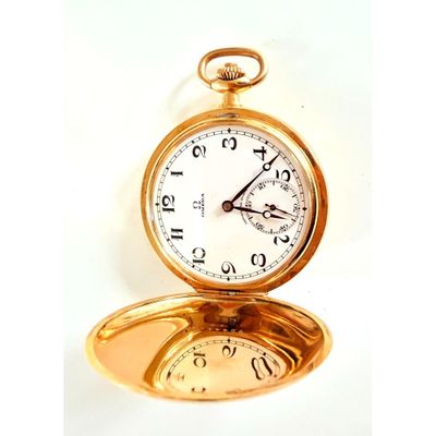 une montre de poche en or posée sur un miroir