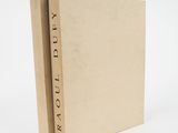 un livre marron avec une inscription noire, posé sur une surface blanche