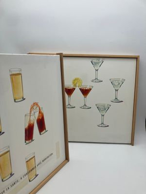 deux photos encadrées représentant des cocktails et des boissons posées sur la table