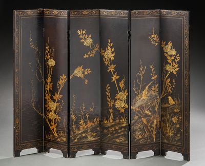 un paravent noir et doré orné de fleurs et d'oiseaux