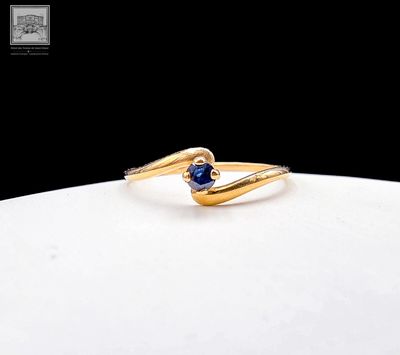 an image of a gold ring with a sapphire stone