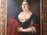 an old painting of a woman in a black dress holding a red blanket