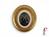 a picture of a woman sitting in a chair in a gold frame