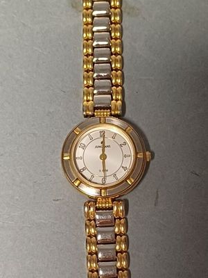 une montre-bracelet en or et en argent posée sur une table