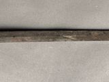 a very long knife that is laying on a table
