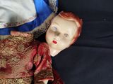 a doll that is laying down on a black surface