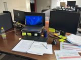 un bureau sur lequel se trouvent un ordinateur portable, un écran, un clavier, une souris et d'autres objets