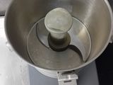 a metal bowl with a metal handle on top of a scale
