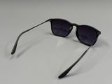 une paire de lunettes de soleil noires posée sur une surface blanche