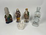 several figurines of asian people are lined up on a white surface