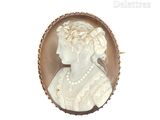 une photo d'une femme portant un collier de perles et une broche