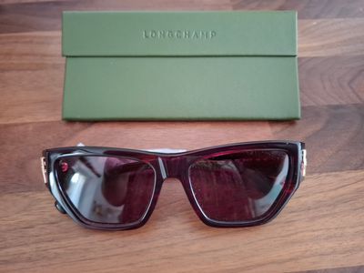 une paire de lunettes de soleil posée sur une table à côté d'une boîte verte