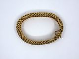a close up of a gold bracelet on a white surface
