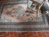 a rug on the floor next to a chair on the floor