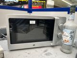 une bouteille de vodka posée à côté d'un micro-ondes sur un plan de travail