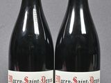 two bottles of red wine sitting next to each other on a table