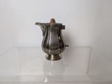a silver pitcher sitting on a glass table