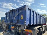 a blue dump truck that is parked on the side of the road