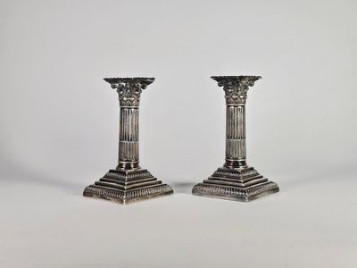une paire de chandeliers en argent sur fond blanc