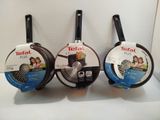 three frying pans sitting on top of a white counter top