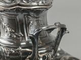 a silver plate with a silver tea pot on it
