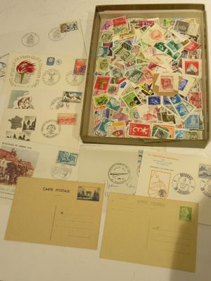 a box of stamps sitting on a table next to a bunch of postcards