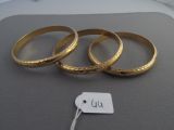 three gold rings with a price tag are on a table