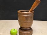 mortar and apple on a table with a blackboard in the background