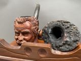 a statue of a man holding a pipe and a pipe holder