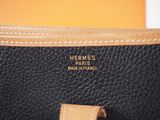 a close up of a black purse with a brown handle