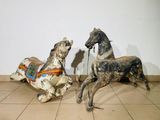 two wooden horses that are sitting on a tile floor