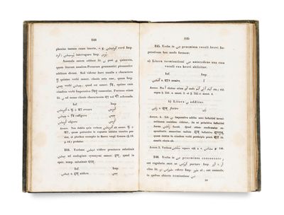 un livre ouvert avec une écriture dessus, posé sur une table