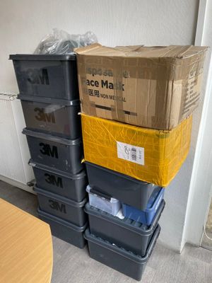 des cartons empilés les uns sur les autres dans une pièce, à côté d'une table