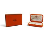 an orange box with a ring inside of it on a white surface