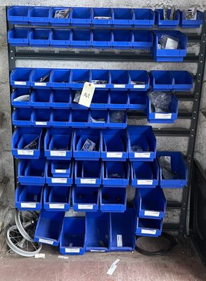 de nombreux bacs bleus empilés sur un support dans un garage