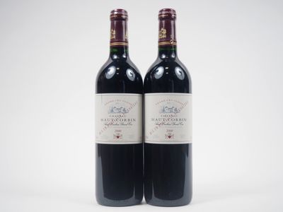 deux bouteilles de vin rouge posées l'une à côté de l'autre sur une surface blanche