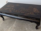une table basse noire ornée d'un motif floral