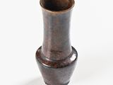 a small brown vase sitting on a white surface