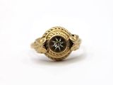 a close up of a gold ring with a black stone in the center