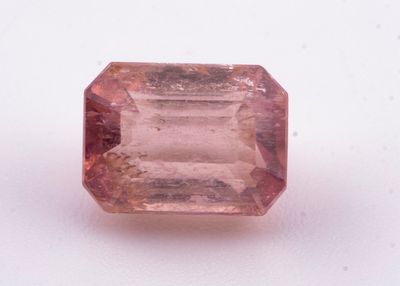 un gros plan d'un saphir rose posé sur une surface blanche