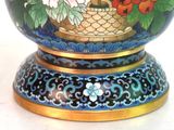 a blue vase with flowers painted on it on a table