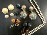 a close up of a necklace and earrings on a table