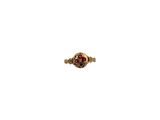 gros plan d'une bague en or avec une pierre rouge