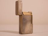 silver metal cigarette case sitting on top of a white surface