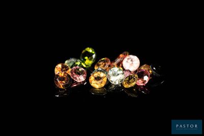 a close up of three different colored gems on a black background