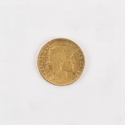 une vieille pièce d'or sur une surface blanche avec un fond blanc