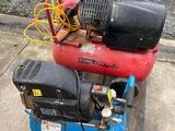 two air compressors sitting on a pallet on the sidewalk