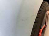 a close up of a car ' s front bumper and tire