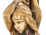 a statue of a woman holding a vase over her head